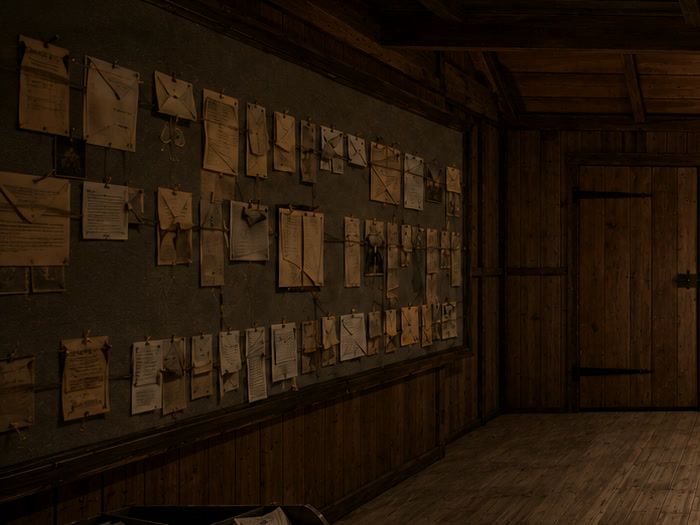 A wall of pages, pinned in rows and joined by lengths of cord.